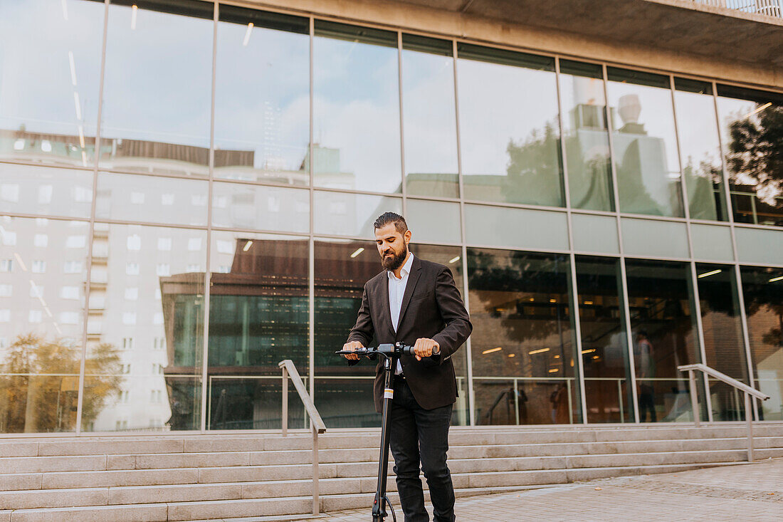 Businessman riding scooter