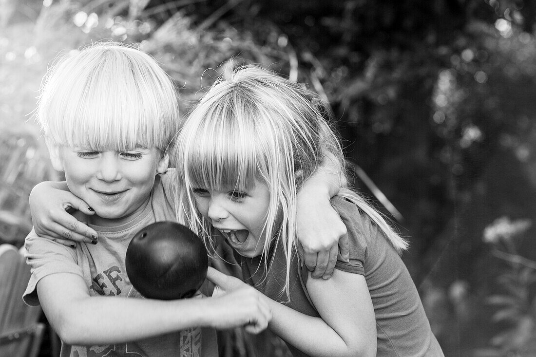 Brother and sister playing with boy