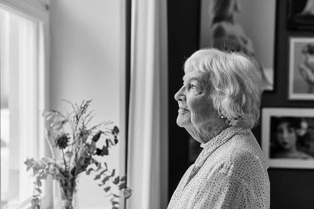 Senior woman looking through window