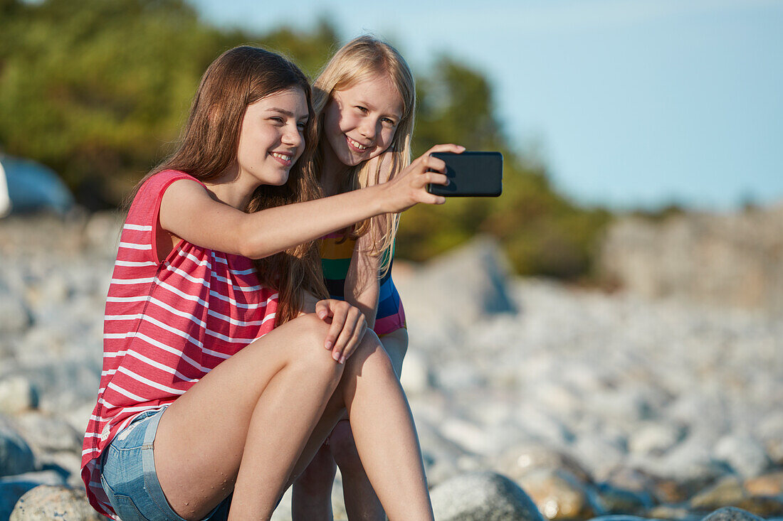 Mädchen machen Selfie am Strand