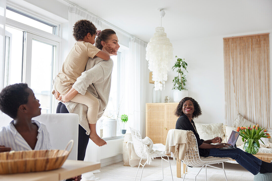 Mother giving son piggyback ride at home