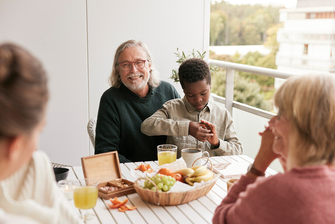 Family sitting at table on balcony