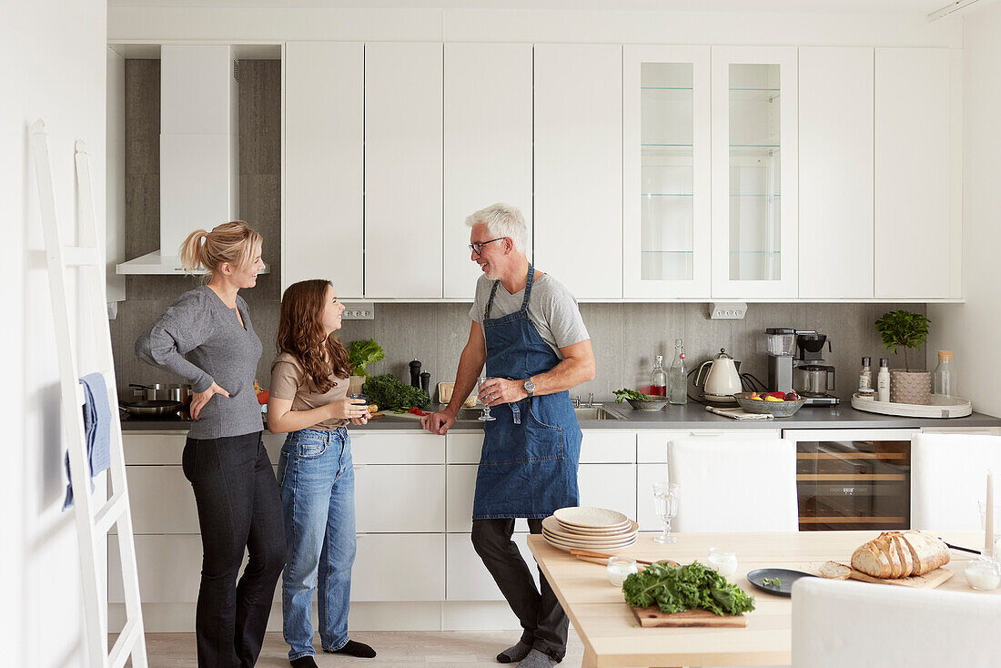 Family standing in kitchen