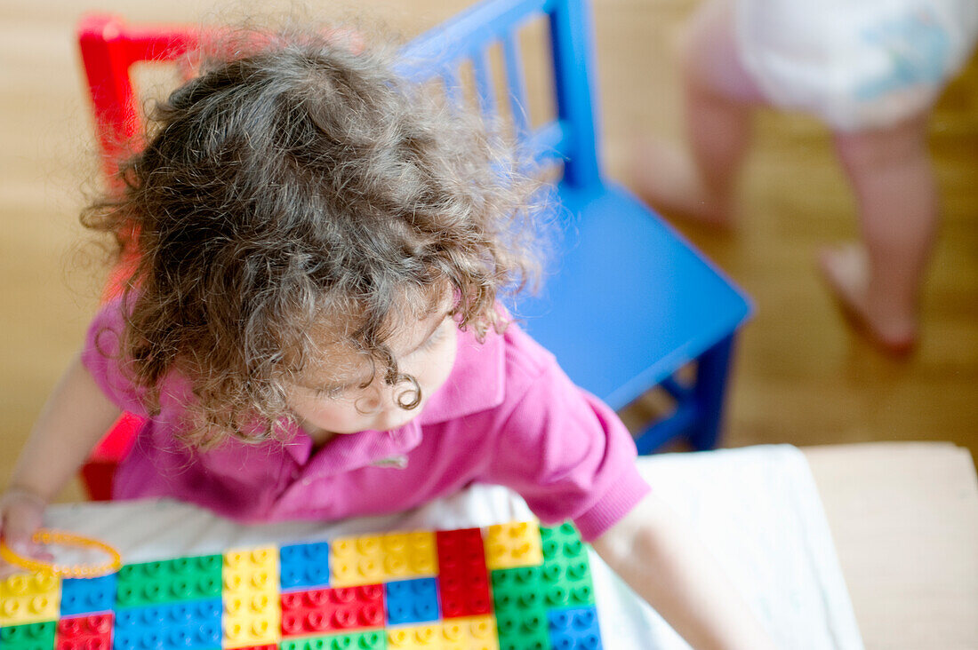 Kleines Mädchen spielt mit Lego