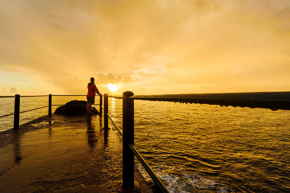 Person auf dem Bootssteg bei Sonnenuntergang