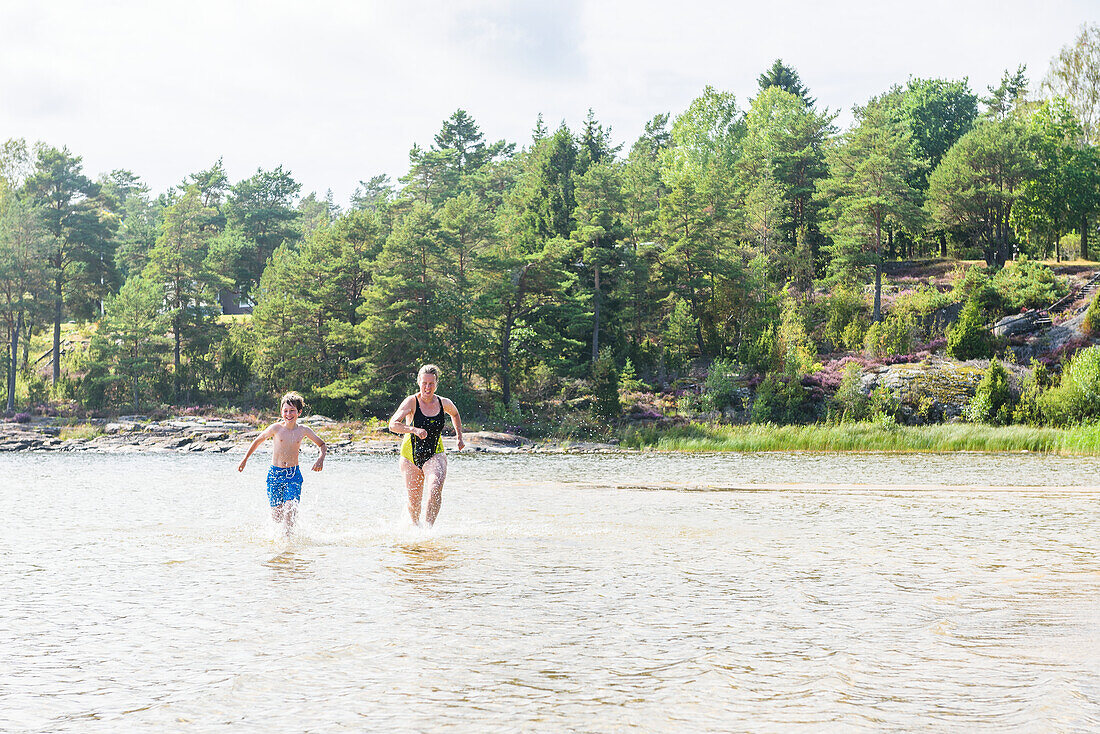 Mother and son running through water