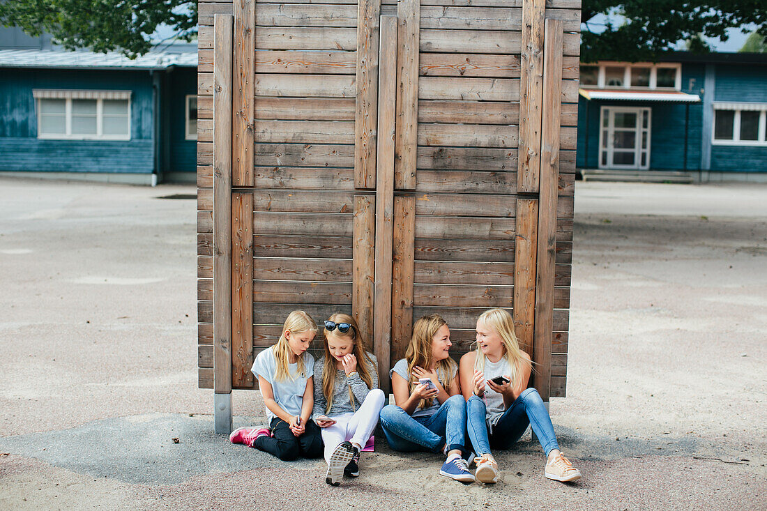 Girls sitting together and using cell phones