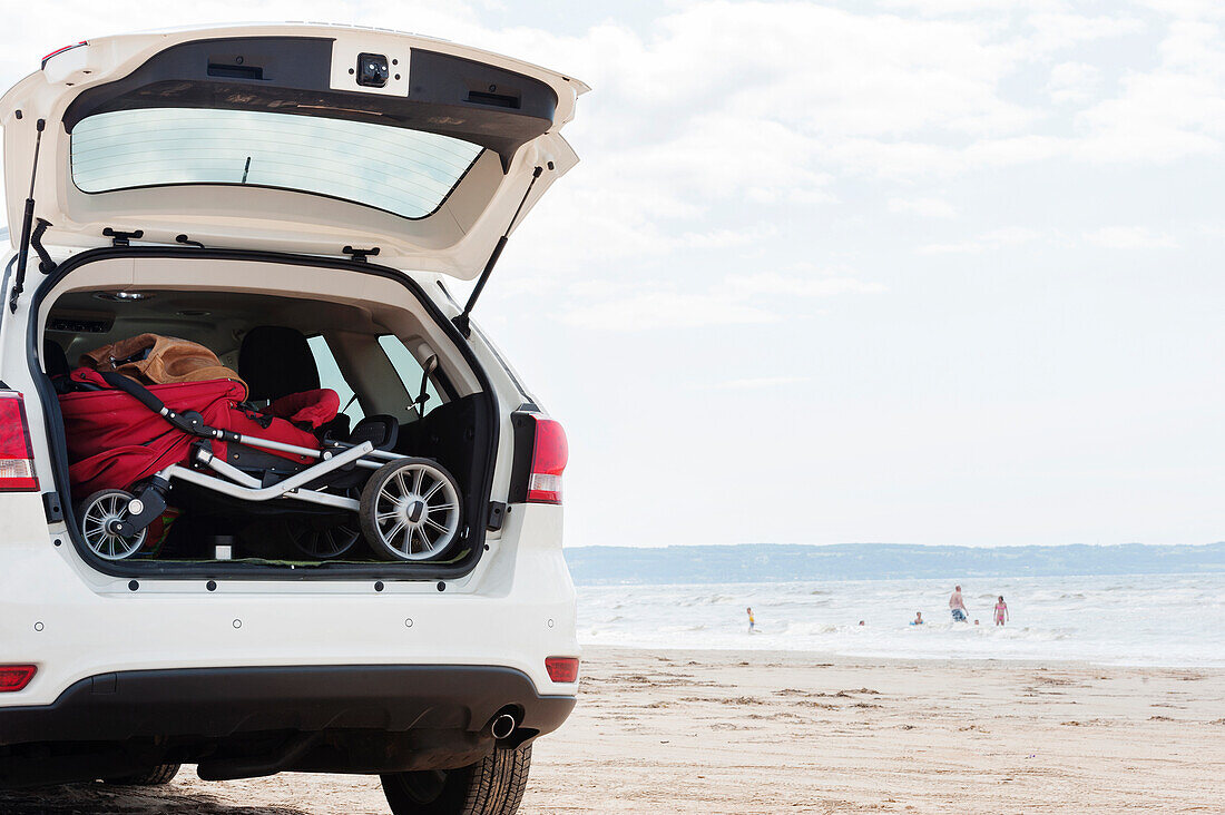 Kinderwagen im Kofferraum eines Autos am Strand am Meer