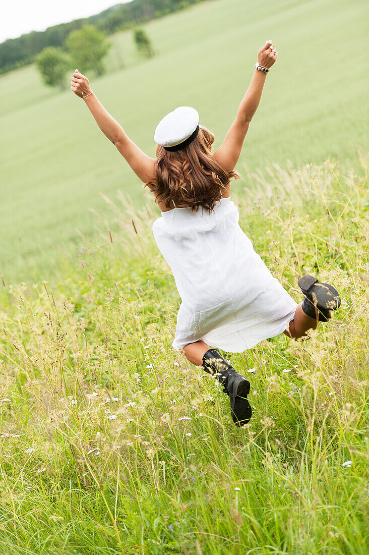 Young woman jumping in field