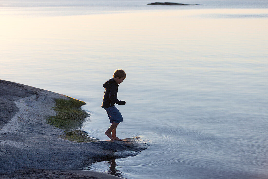 Boy standing by lake