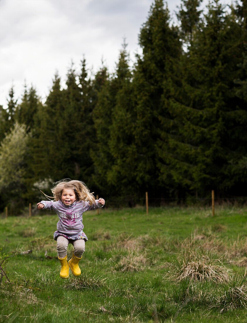 Small girl jumping in forest