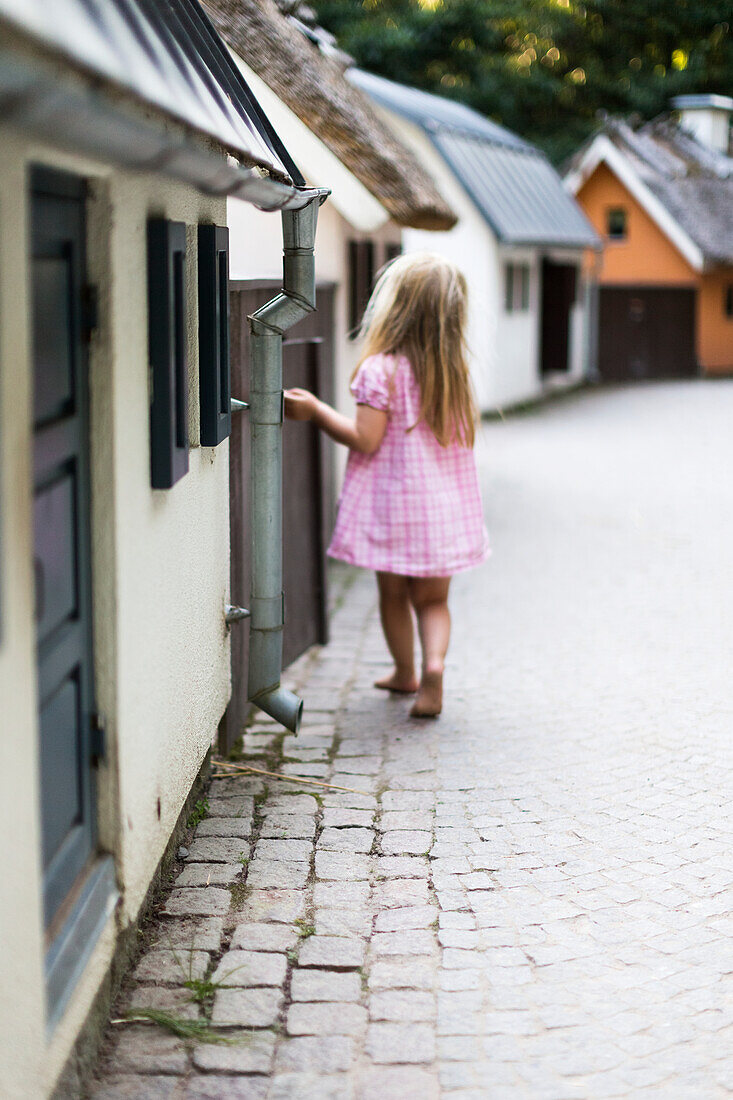 Kleines Mädchen in rosa Kleid läuft
