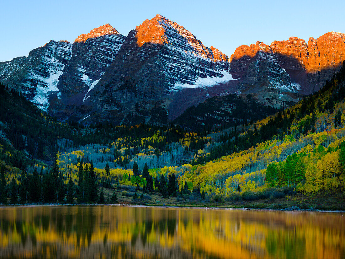 Autumn forest reflecting in mountain lake