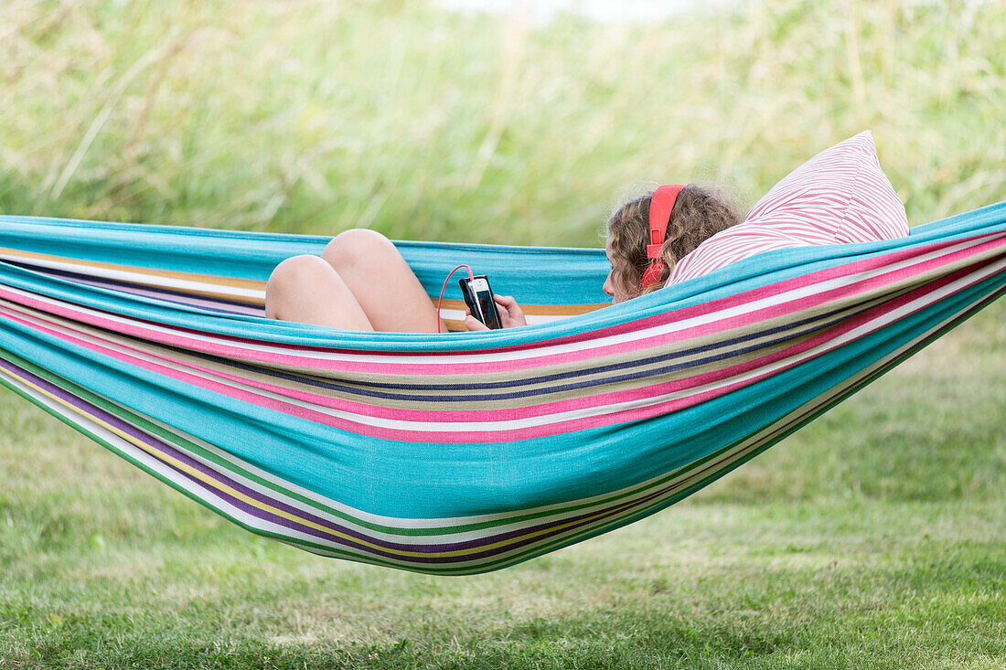 Mädchen in der Hängematte mit Mobiltelefon