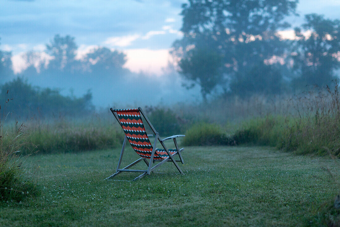 Leerer Liegestuhl in der Abenddämmerung