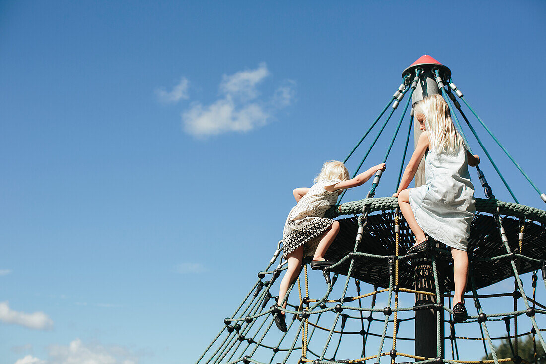 Girls climbing jungle gym