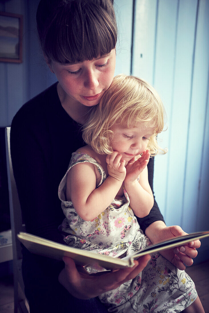 Mother reading book to her daughter