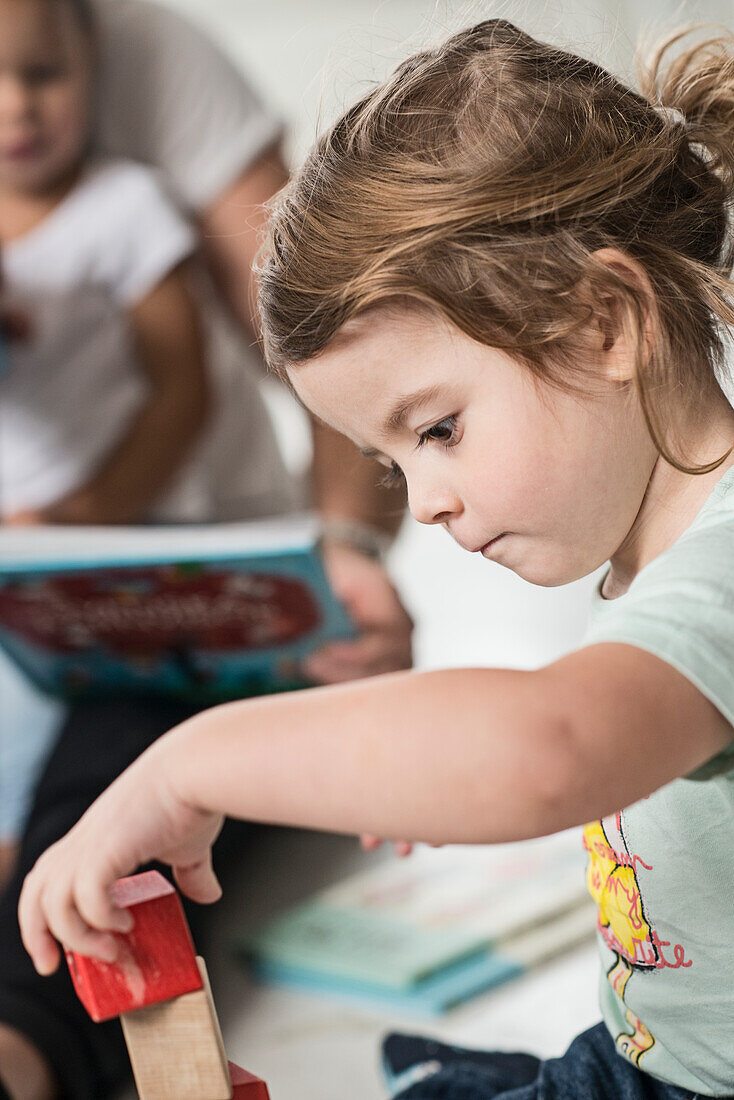 Small girl playing with wooden blocks