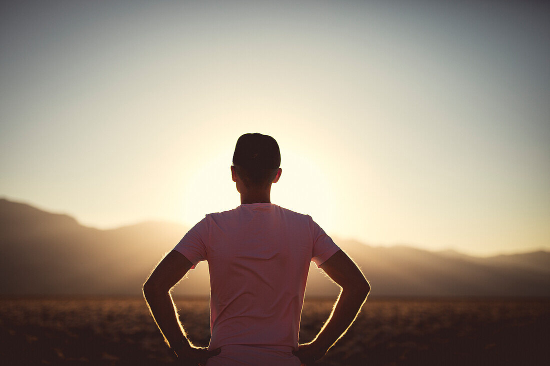 Man looking at sunrise over Death Valley