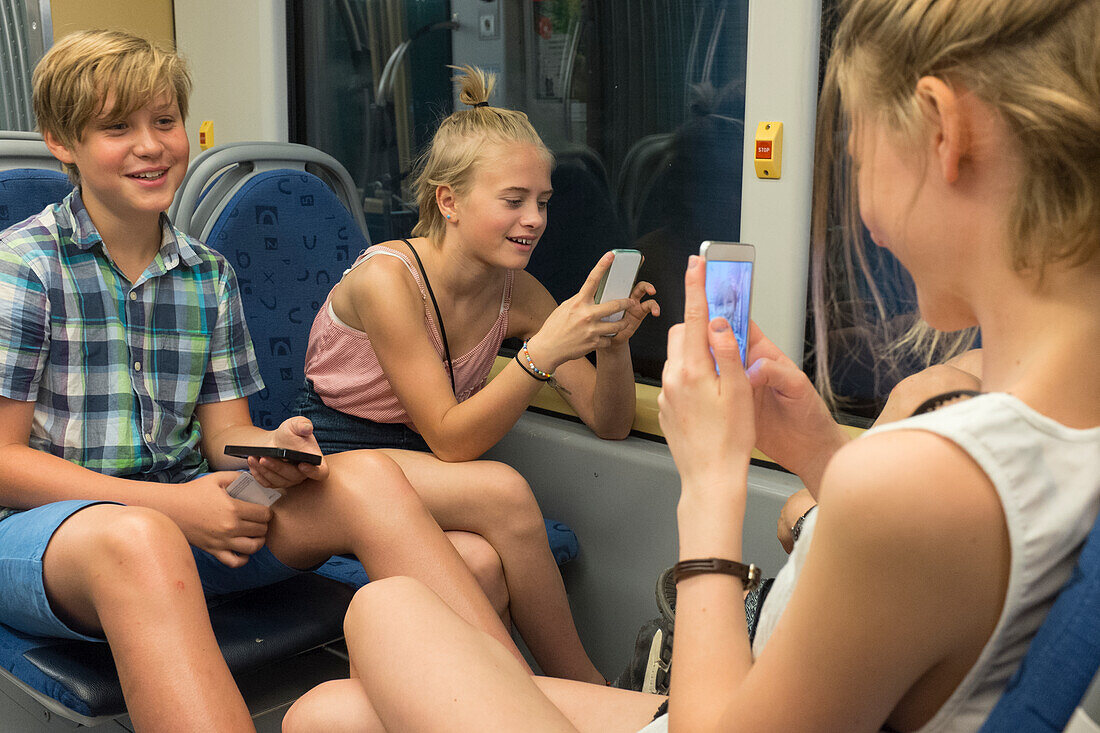 Children with smartphones on train