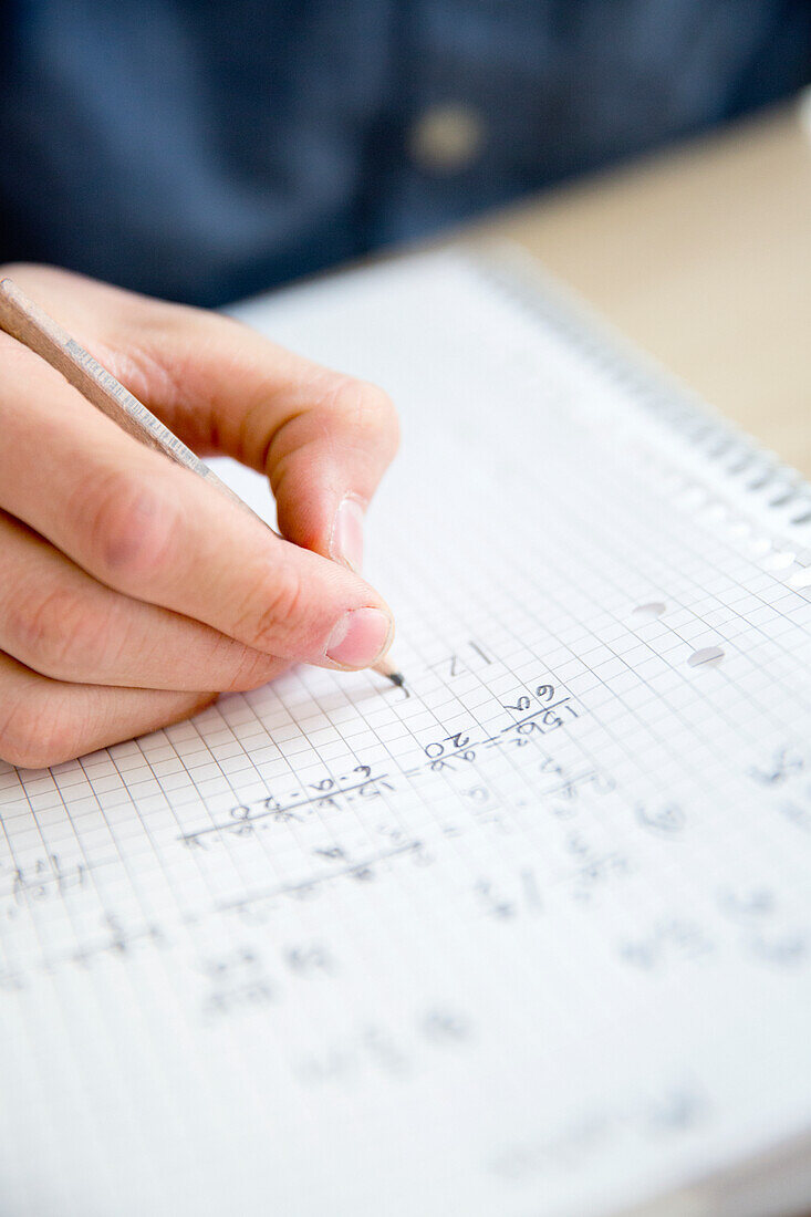 Teenager writing in textbook