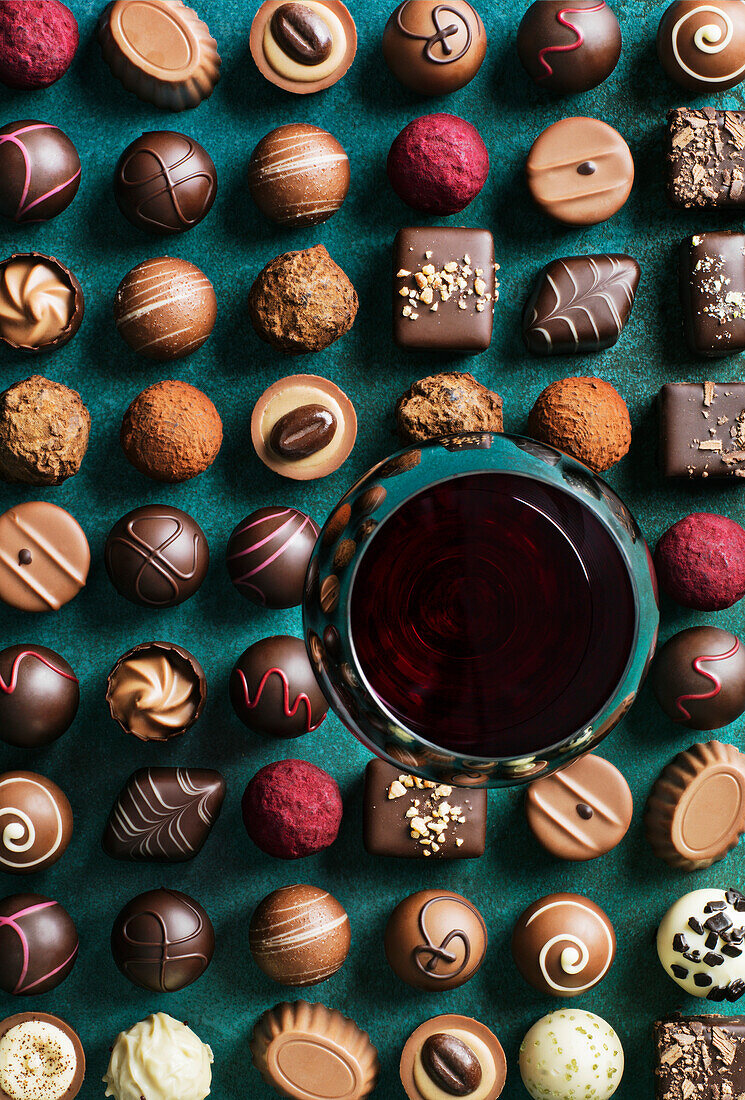 Rotwein und verschiedene Schokoladentrüffel und Bonbons