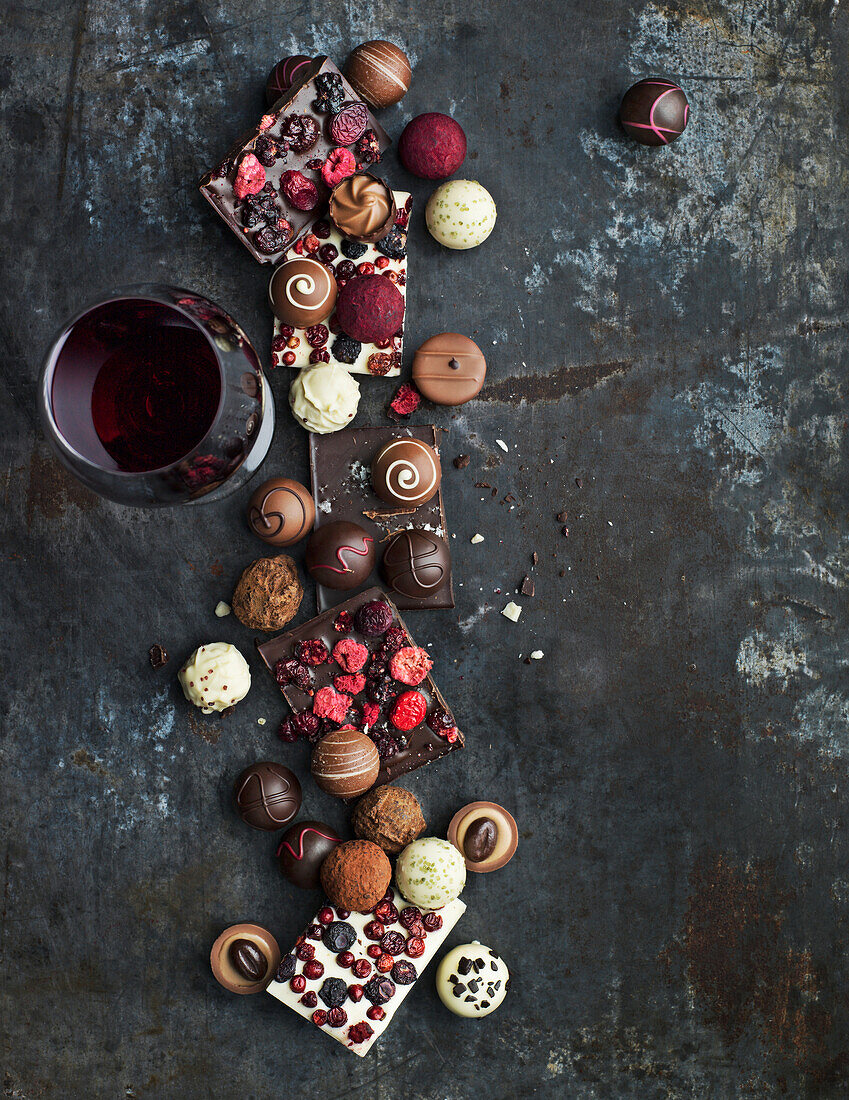 Rotwein und verschiedene Schokoladentrüffel und Bonbons