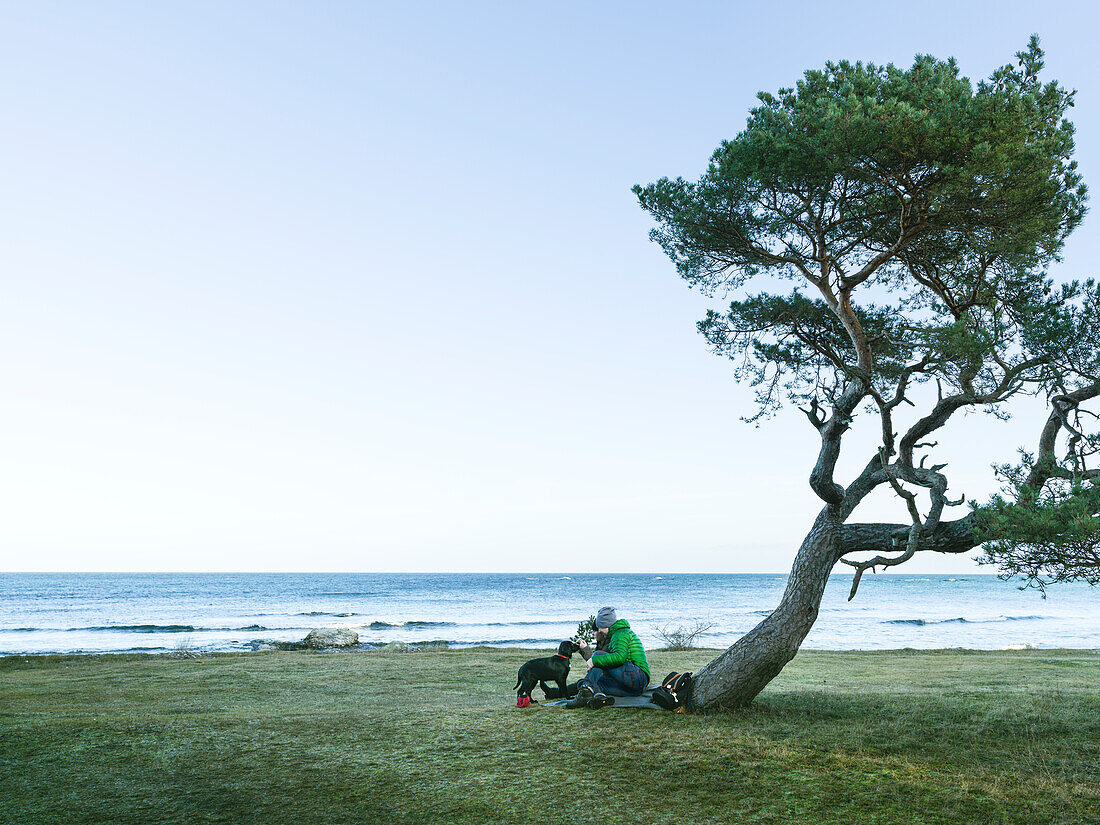 Frau mit Hund am Meer