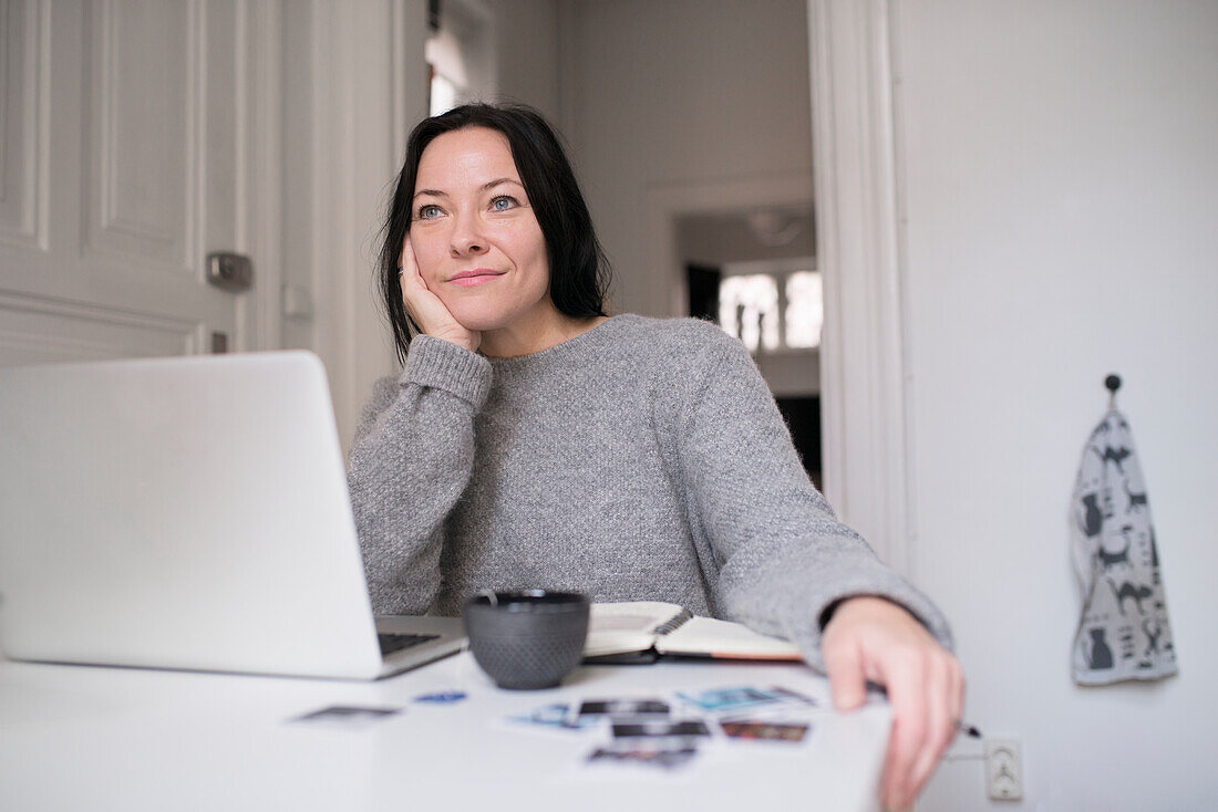 Woman sitting by laptop