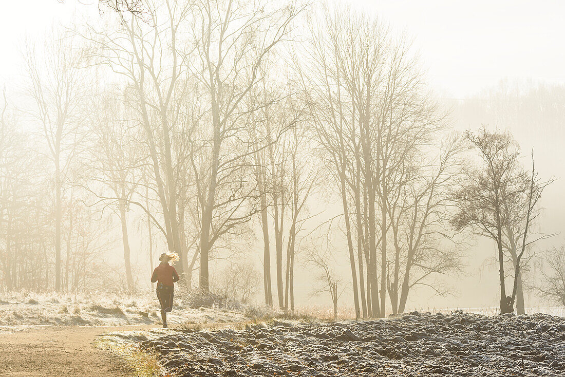 Woman jogging at foggy morning