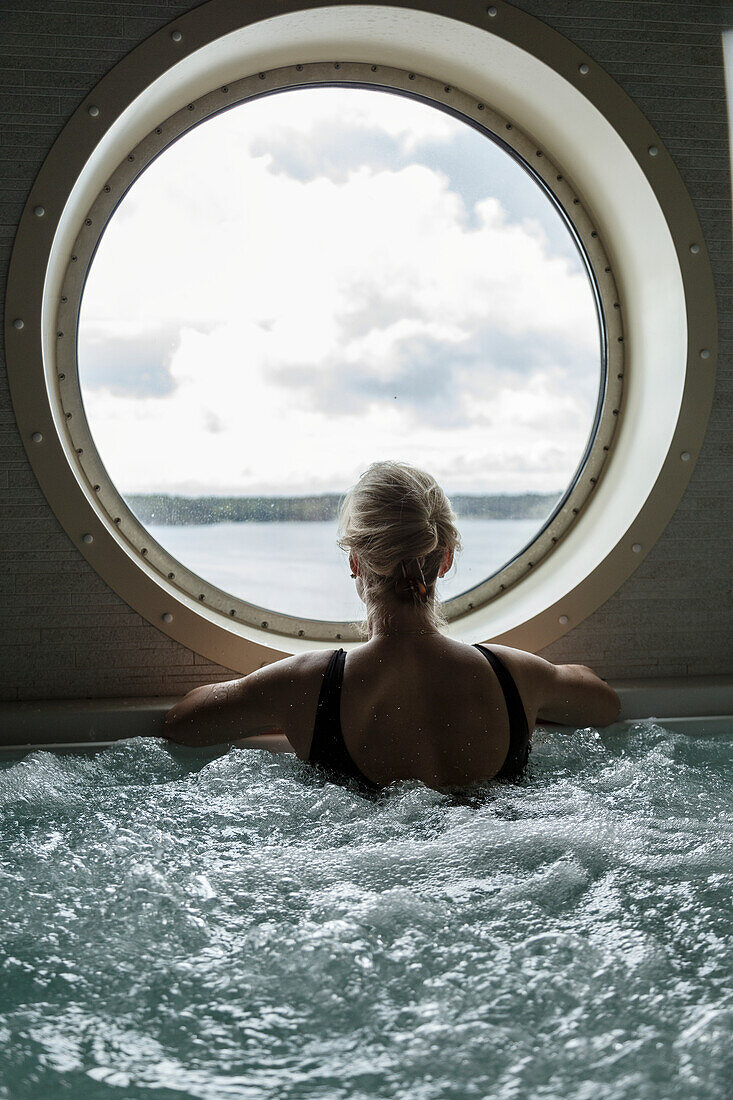 Woman in hot tub looking through window