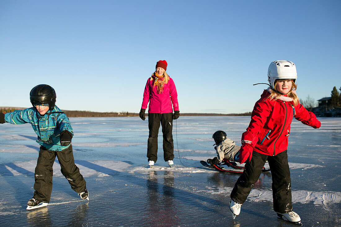 Mother with children skating on lake
