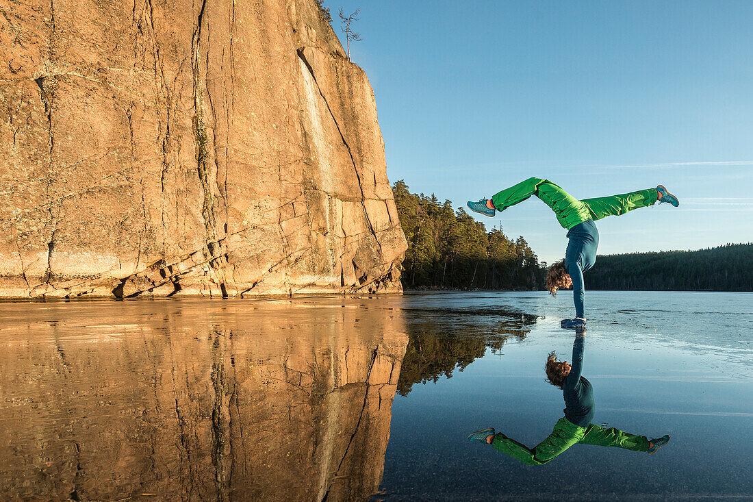 Frau macht Yoga auf einem zugefrorenen See