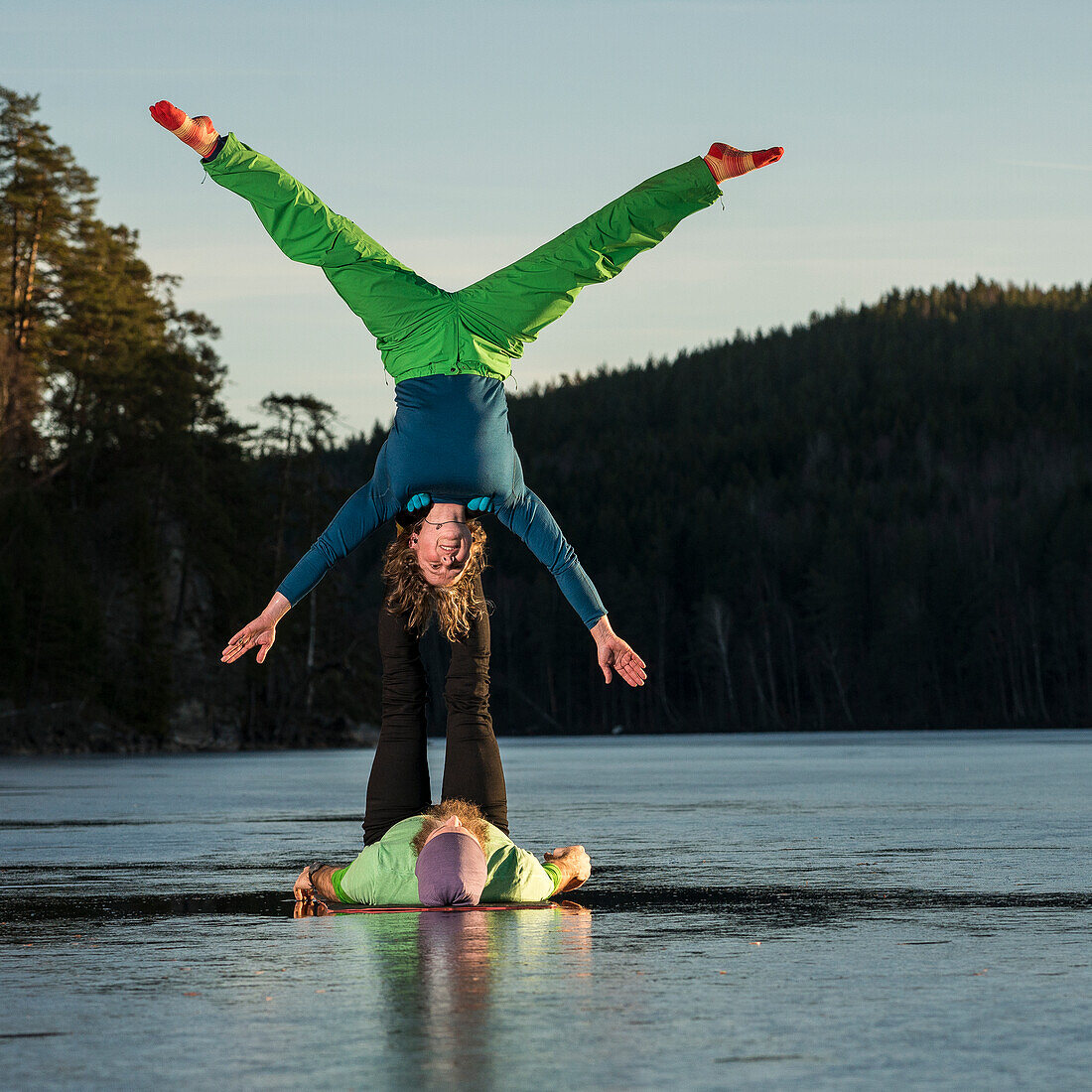 Paar macht Yoga auf zugefrorenem See