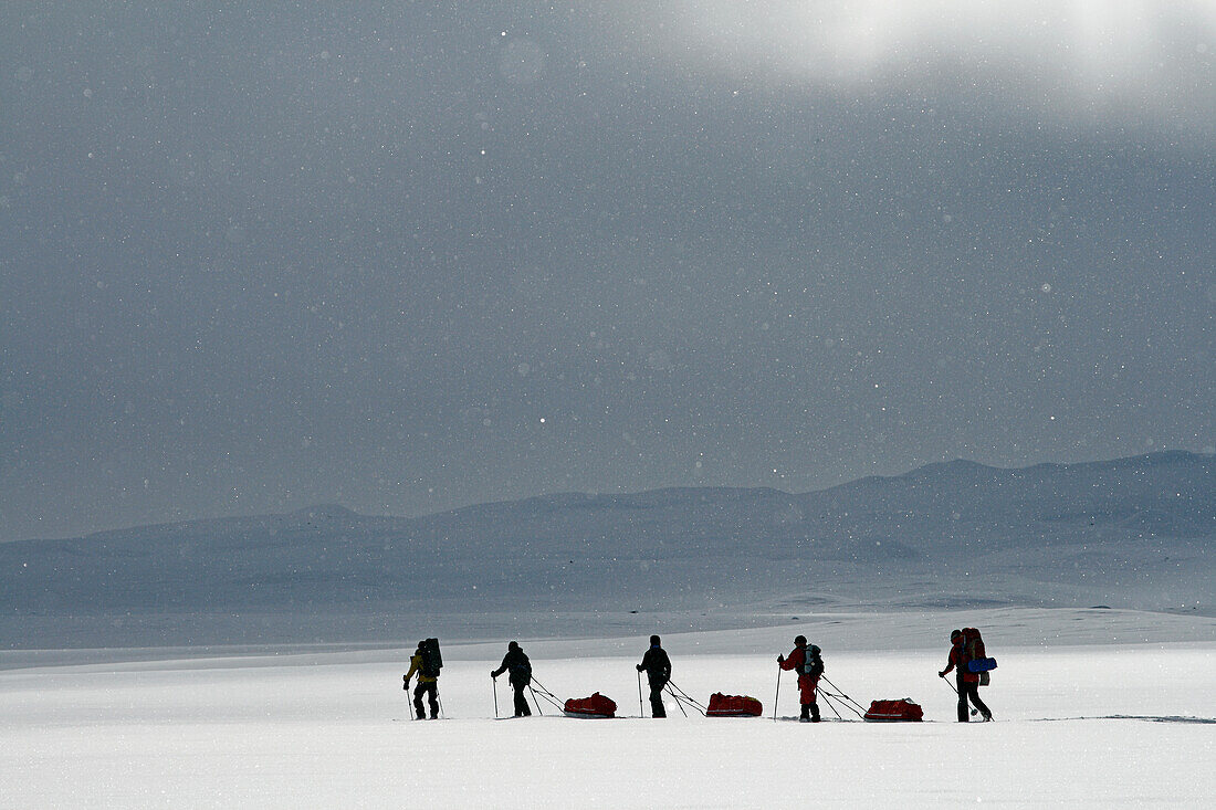 Tourists cross country skiing against mountain scenery