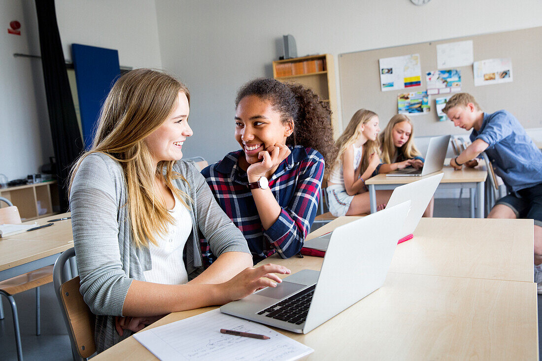 Teenager mit Laptop im Klassenzimmer