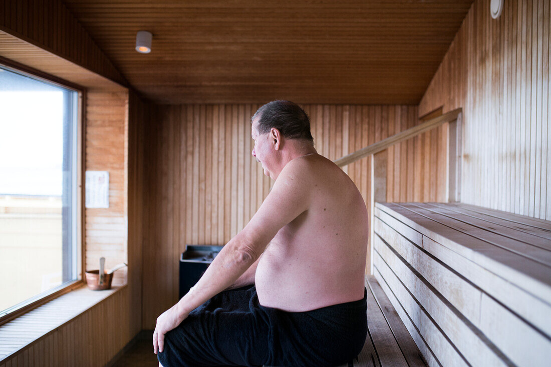 Reifer Mann sitzt in der Sauna