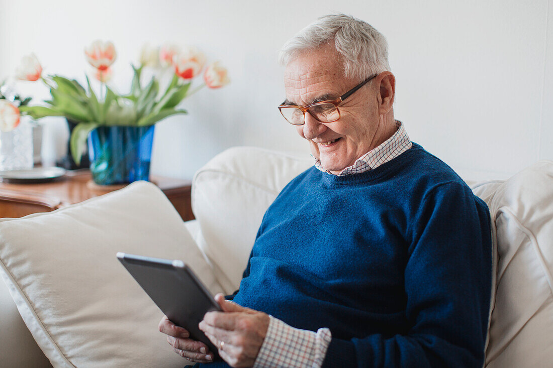 Älterer Mann mit digitalem Tablet