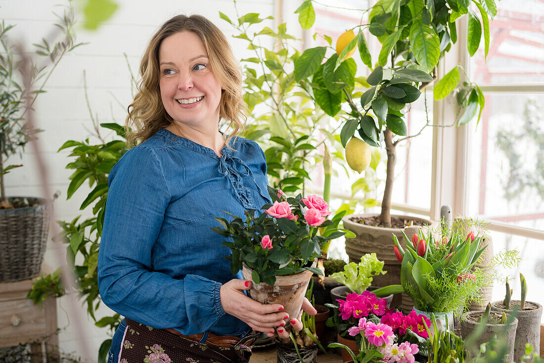 Woman planting flowers in winter garden