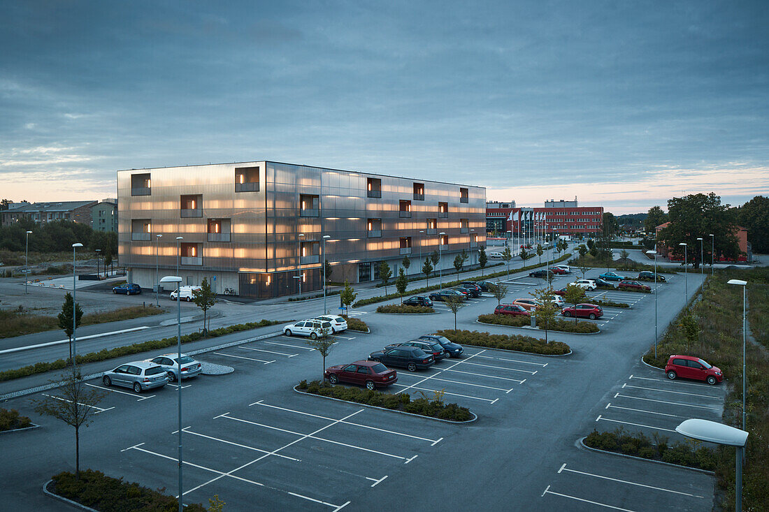 Modern residential building and parking lot at dusk