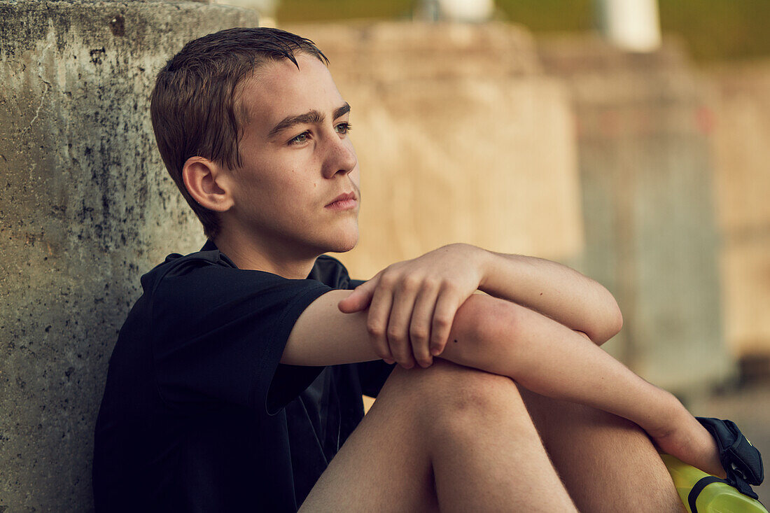 Serious teenage boy against concrete wall