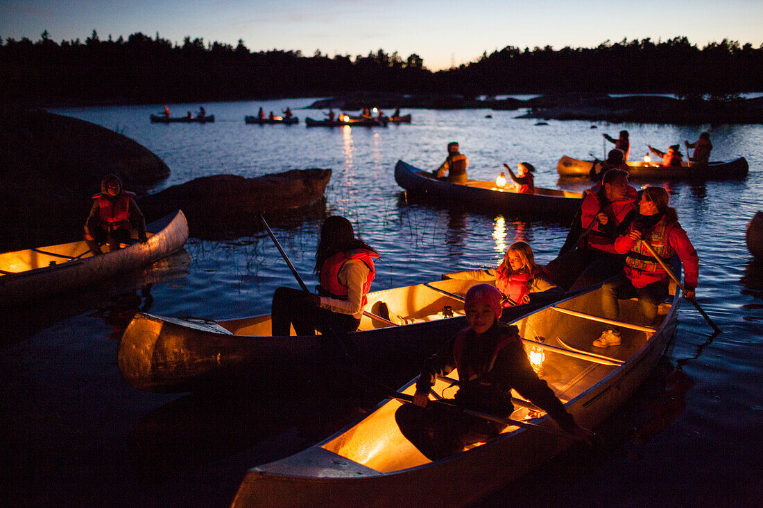Children in canoes a summer evening.