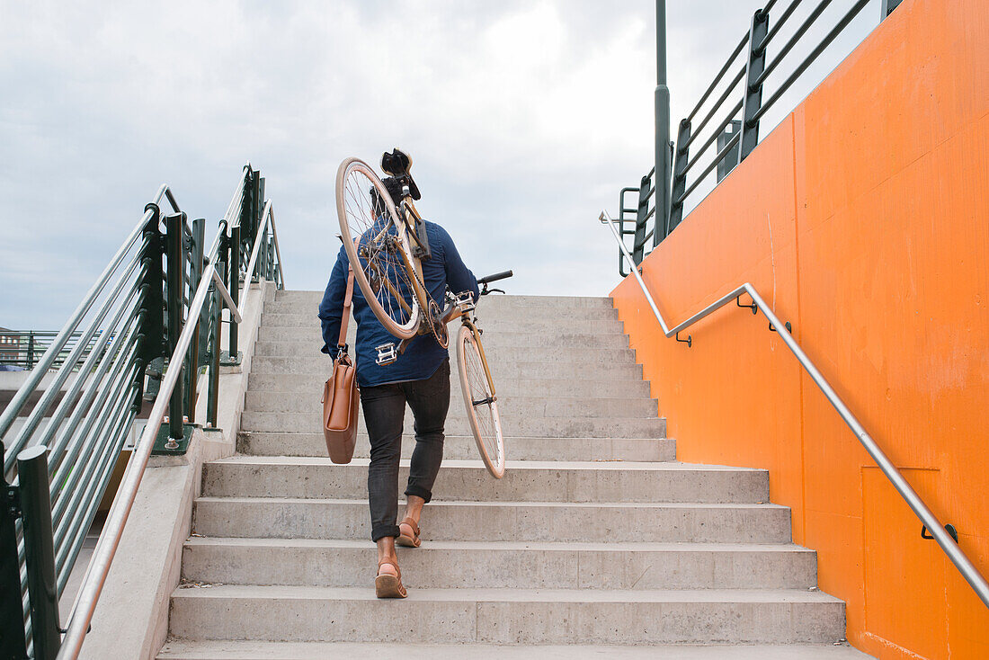 Man carrying bicycle on steps