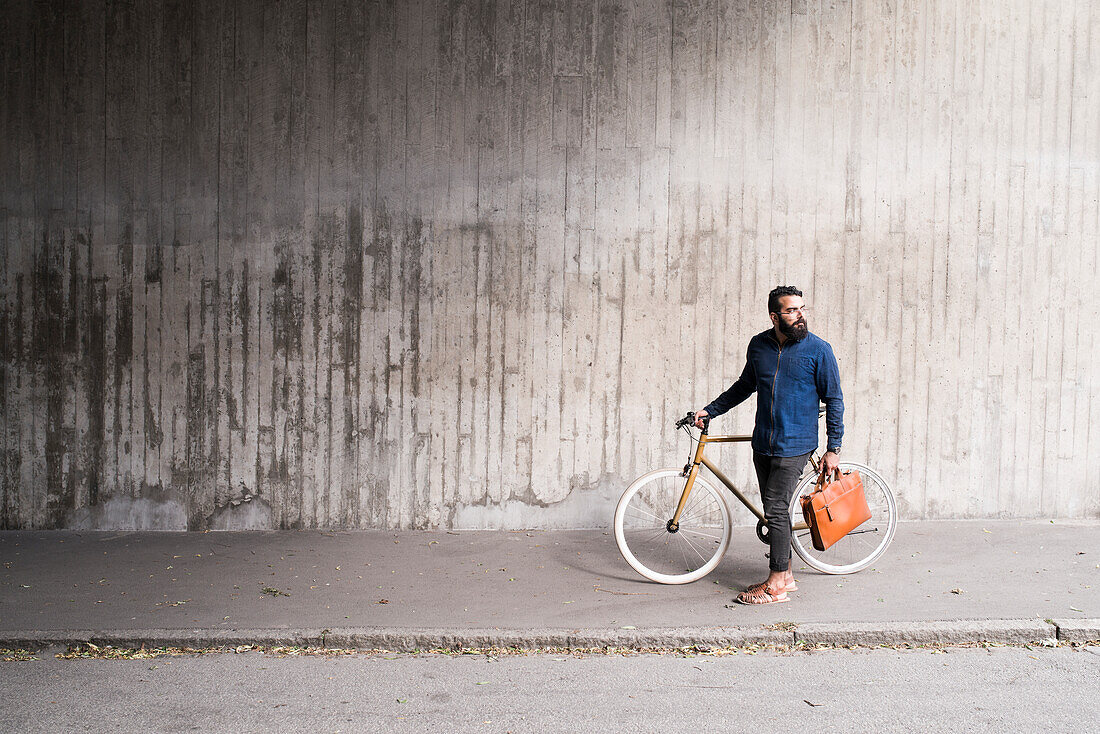 Mann mit Fahrrad im Tunnel stehend