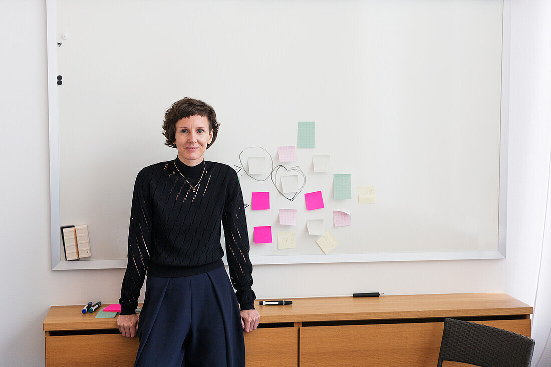 Smiling woman in front of white board