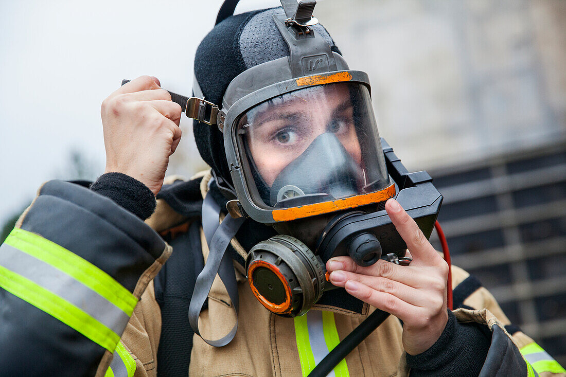 Feuerwehrfrau setzt Maske auf