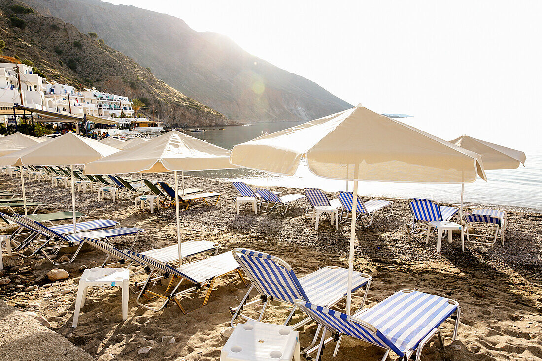 Sonnenschirme mit Liegestühlen am Strand