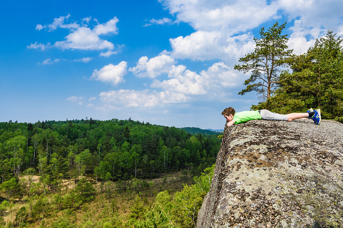 Junge entspannt sich auf einem Felsen