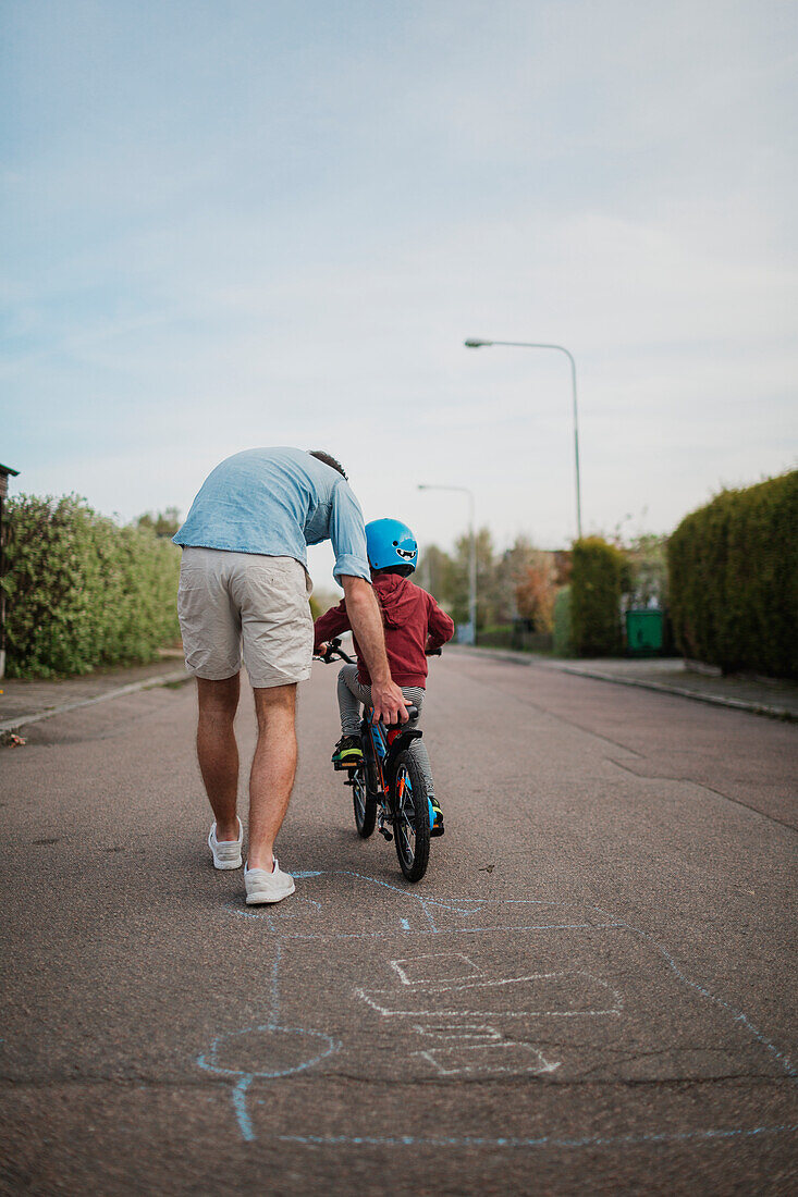 Vater bringt Sohn Radfahren bei