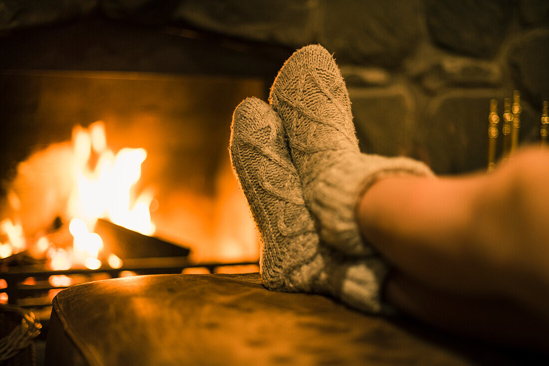 Füße in Wollsocken am Kamin